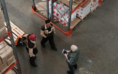 Workers discuss logistics in a busy warehouse setting, enhancing teamwork and efficiency.